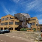 Modern brick office building under blue sky.
