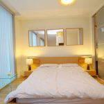 Modern bedroom with double bed and mirrors.
