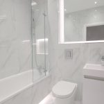 Modern white marble bathroom with bathtub and sink