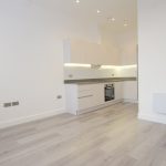 Modern minimalist kitchen with white cabinets and oven.