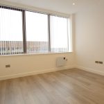 Empty room with large window and wooden floor