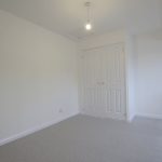 Empty white-walled room with closed double doors.