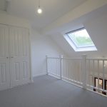 Bright attic room with skylight and cupboard.