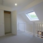 Bright loft room with skylight and open wardrobe.
