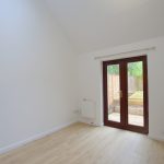 Bright room with wooden floor and garden view.