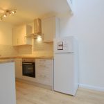 Modern kitchen with wooden worktops and appliances.