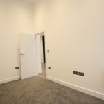 Empty room with beige walls and grey carpet