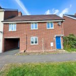 Modern brick house with blue door and driveway.