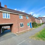 Modern brick house with archway and blue door.