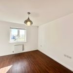 Bright empty room with wooden floor and window.