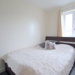 Cosy bedroom with double bed and window view.