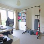 Home office with gym equipment and computer setup.
