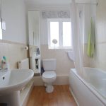 Modern bathroom with sink, toilet and bathtub.