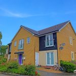 Modern two-storey house with a garden and bike.