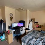 Cluttered bedroom with computer and boxes