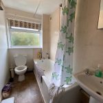 Small bathroom with bathtub, sink, and toilet.