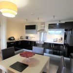 Modern kitchen with black cabinets and dining table.