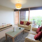 Modern living room with sofas and balcony view.