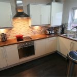 Modern kitchen with appliances and wooden worktops.