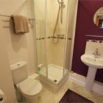 Modern bathroom with shower, sink, and toilet.