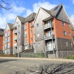 Modern brick apartment building under blue sky.