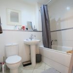 Modern bathroom with bath, sink, and toilet.