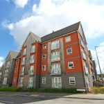 Modern red brick apartment building on UK street