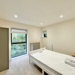 Bright bedroom with bed, wardrobe, and large window