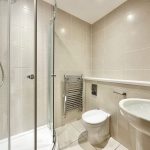 Modern bathroom with shower and neutral tiles.