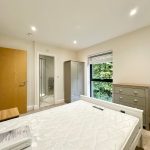 Modern bedroom with ensuite and garden view.
