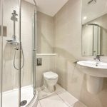 Modern bathroom with shower, sink, and toilet.