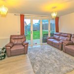 Cosy living room with leather sofas and garden view.