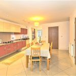 Modern kitchen and dining area with table and chairs.