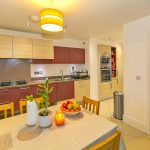 Modern kitchen with dining table and appliances.