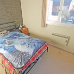 Small bedroom with single bed and window view.