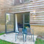 Open patio doors with two chairs outside.