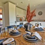 Modern kitchen and dining area with table setting.
