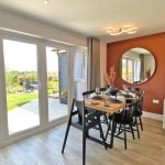 Dining area overlooking garden with patio doors.