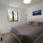 Cosy bedroom with double bed and window view.