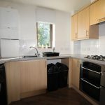 Modern kitchen with appliances and wooden cabinets.