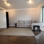 Modern living room with grey sofa and wooden floor.