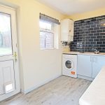 Modern kitchen with appliances and tiled backsplash.