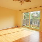 Empty room with wooden floor and patio doors.