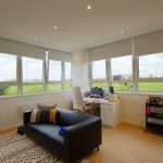Bright office with large windows and modern furniture.