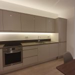 Modern kitchen with grey cabinets and built-in appliances.