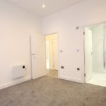 Empty room with open doors and carpet.