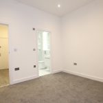 Modern empty room with en-suite bathroom and carpet