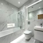 Modern white marble bathroom with bathtub and toilet