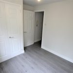 Empty room with white doors and wooden floor