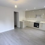 Modern kitchen with white cabinets and grey flooring.